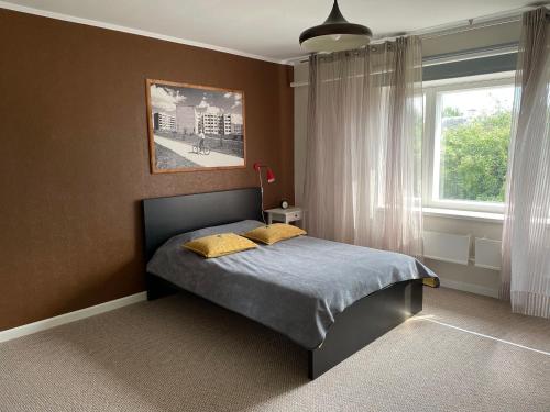 una camera da letto con un letto con cuscini gialli e una finestra di Work & Sleep with sauna a Võru