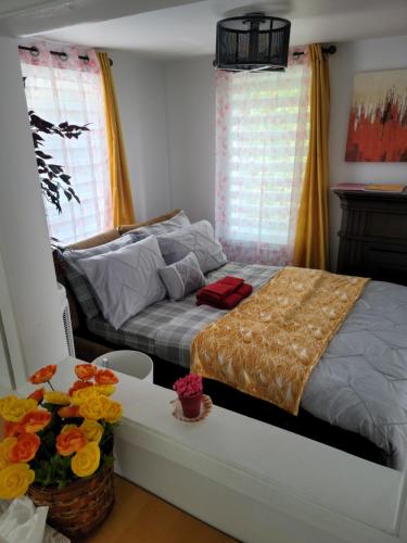 a bedroom with a bed and a table with flowers on it at Vibrant apartment in the heart of the town in Edmundston