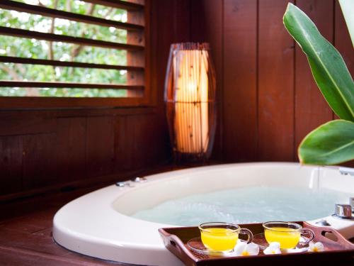 a bath tub with two glasses of orange juice at Coco Garden Resort Okinawa in Uruma