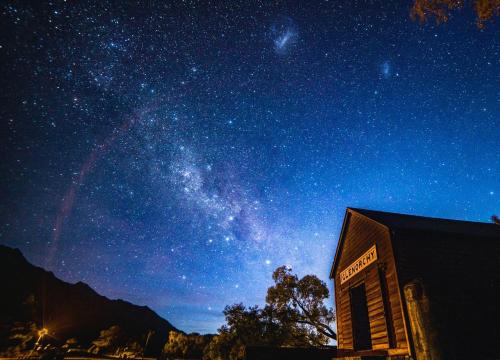 a starry night with the milky way behind a building at Glenorchy Retreat Apartment in Glenorchy