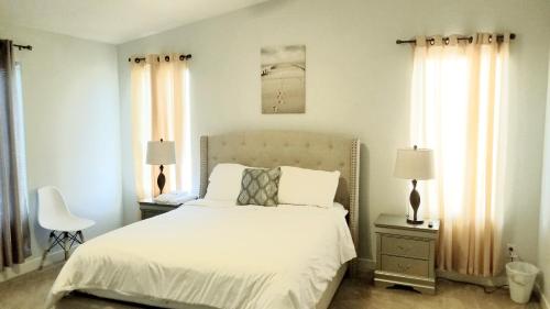 a bedroom with a white bed and two windows at Phoenix comfort home BNB in Phoenix