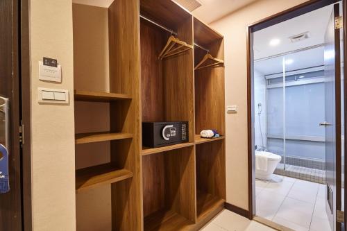 a bathroom with wooden shelves and a toilet at Hotel Leisure Beitou in Taipei