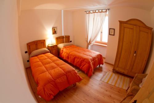 a bedroom with two beds and a window at Tesino Appartamenti 2 in Castello Tesino