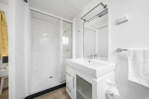 
a bathroom with a sink, toilet and shower at Esk Caravan Park & Rail Trail Motel in Esk
