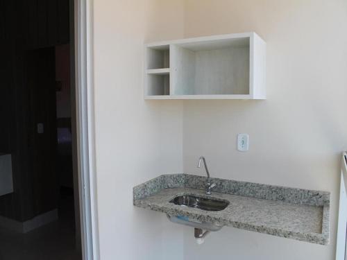 a stone sink in a white wall with a mirror at Piazza Acqua Park in Caldas Novas