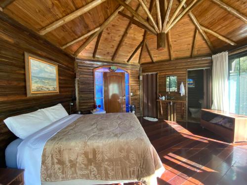 um quarto com uma cama num quarto de madeira em Chalé da Lua Santuário Bellatrix em Ribeirão Amarelo