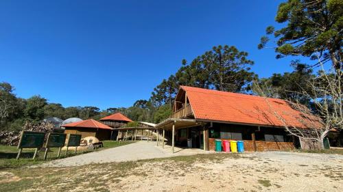 a building with an orange roof on a field at Casa De campo Santuário Bellatrix in Ribeirão Amarelo