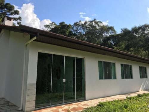a house with sliding glass doors on it at Casa De campo Santuário Bellatrix in Ribeirão Amarelo