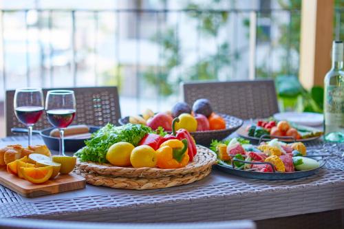einen Tisch mit Obstteller und Gemüse sowie Gläsern Wein in der Unterkunft Terrace Villa Eon in Shirahama
