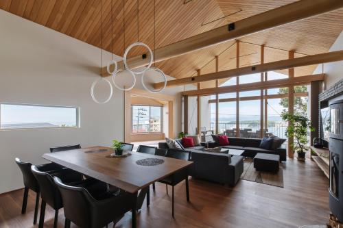 sala de estar con mesa, sillas y sofá en Terrace Villa Eon, en Shirahama