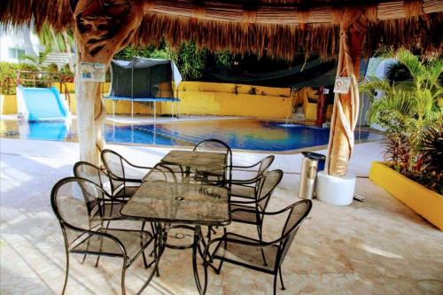 a table and chairs in front of a pool at Condominio familiar y exclusivo Tres Mares in Acapulco