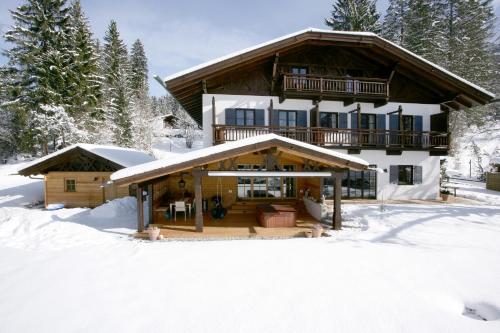 a large log house in the snow with trees at Ferienhaus Heimhof in Garmisch-Partenkirchen