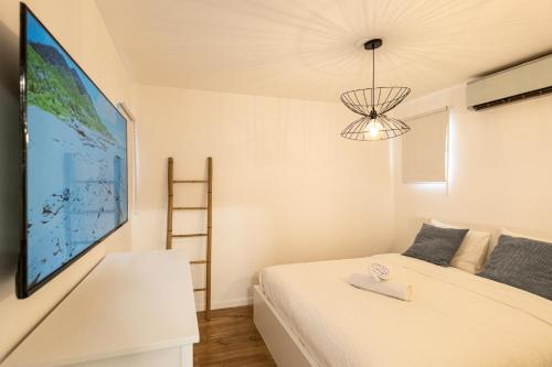 a bedroom with a bed and a large tv on the wall at Eilat vacation house דירות נופש אילת in Eilat