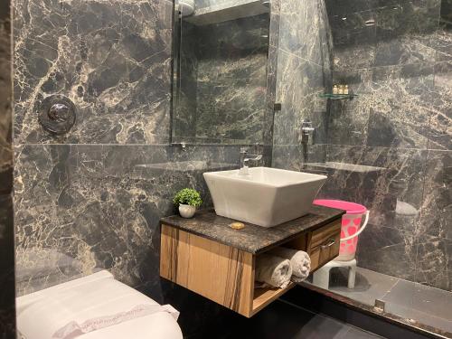 ein Bad mit einem Waschbecken und einem Spiegel in der Unterkunft Hotel Exotic - 5 min walk from Golden Temple in Amritsar