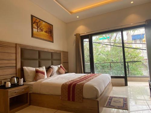 a bedroom with a large bed and a large window at Hotel Exotic - 5 min walk from Golden Temple in Amritsar