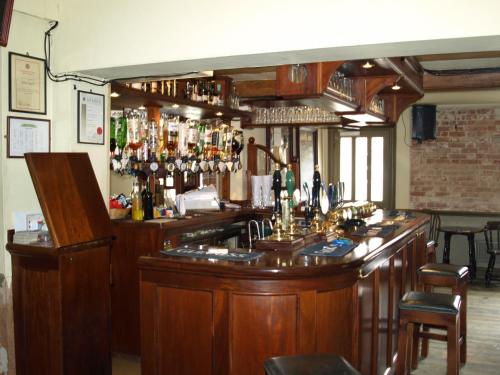 eine Bar in einem Pub mit viel Alkohol in der Unterkunft Jolly Brewers Free House Inn in Bishops Stortford