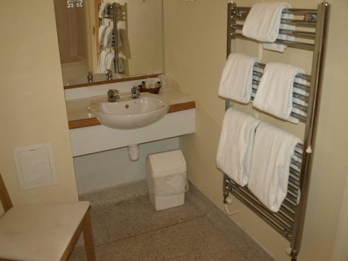 ein Badezimmer mit einem Waschbecken, einem Spiegel und Handtüchern in der Unterkunft Jolly Brewers Free House Inn in Bishops Stortford