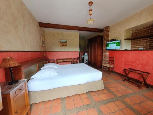 a bedroom with a bed and a tv in it at Les Mout'Anes in Saint-Hilaire-sur-Helpe