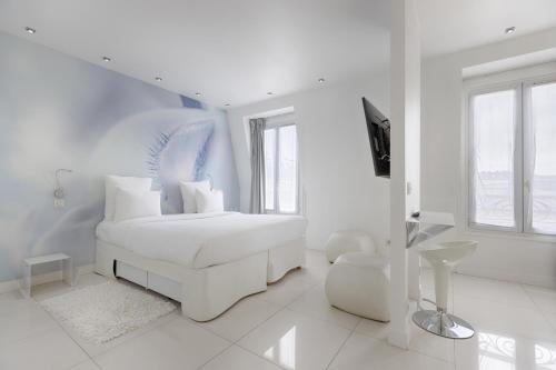 a white bedroom with a white couch and a tv at Blc Design Hotel in Paris