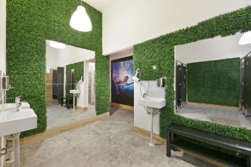 baño con 2 lavabos y pared verde en Tequila Sunrise Hostel Surfers Paradise en Gold Coast