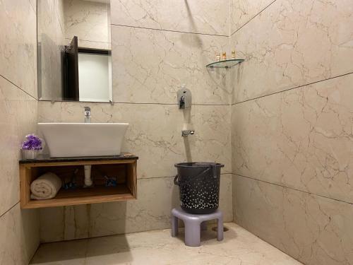 a bathroom with a sink and a trash can at Hotel Exotic - 5 min walk from Golden Temple in Amritsar