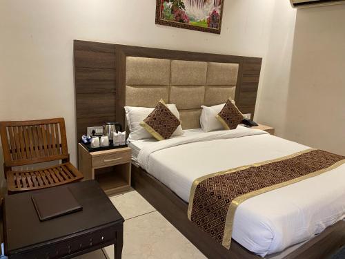 a hotel room with a bed and a chair at Hotel Exotic - 5 min walk from Golden Temple in Amritsar