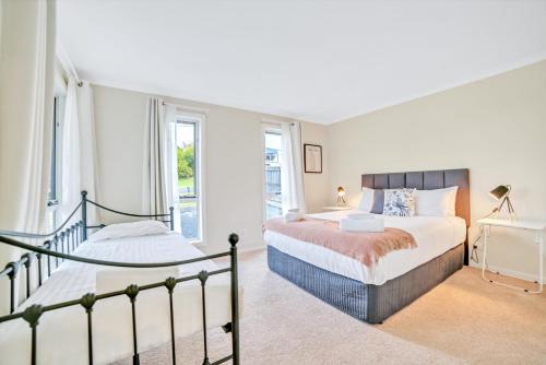 a bedroom with two beds and two windows at Port View Escape in Bridport