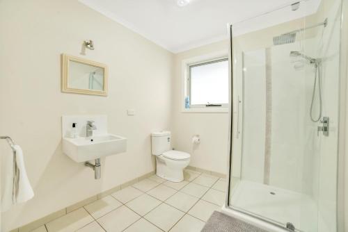 a bathroom with a toilet and a sink and a shower at Port View Escape in Bridport