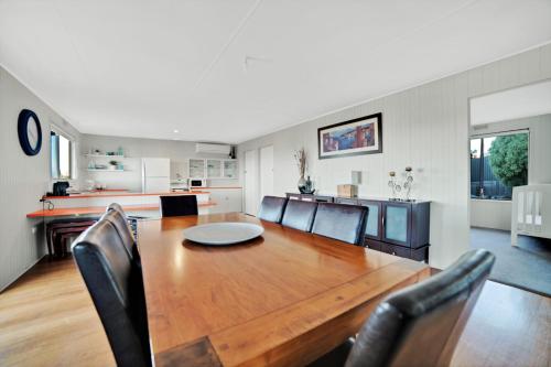 a dining room and kitchen with a wooden table and chairs at Dune Views in Bridport