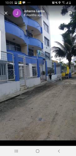 a blue and white building next to a palm tree at Casa blanca Atacames in Atacames
