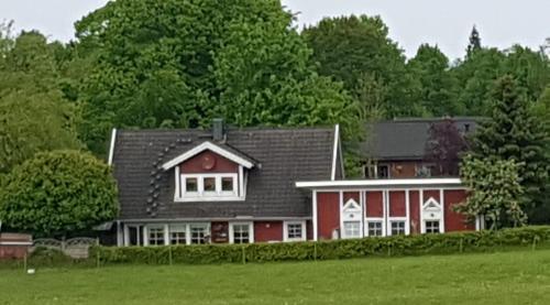 a red house with a black roof at An der Schafsweide in Aukrug