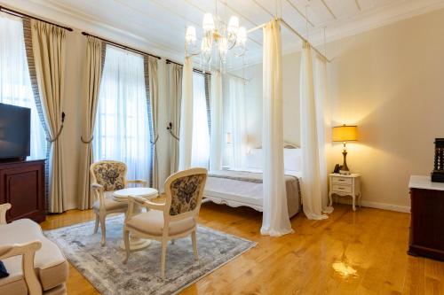 a bedroom with a bed and a table and chairs at Rasim Palas - Adults Only in Cesme
