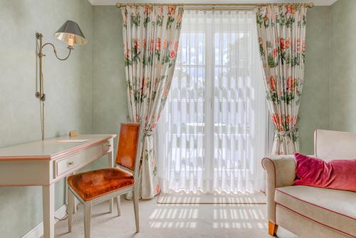 a room with a desk and a window at Wald & Schlosshotel Friedrichsruhe in Friedrichsruhe