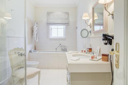 a white bathroom with a sink and a toilet at Wald & Schlosshotel Friedrichsruhe in Friedrichsruhe