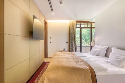 a large bed in a room with a window at Wald & Schlosshotel Friedrichsruhe in Friedrichsruhe