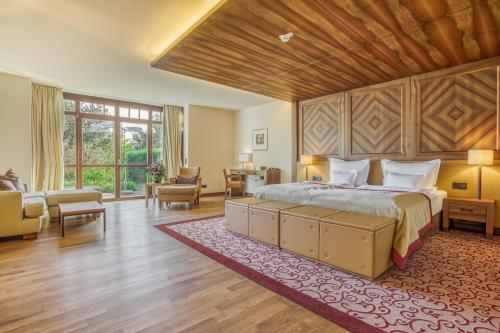 ein Schlafzimmer mit einem großen Bett und einer Holzdecke in der Unterkunft Wald & Schlosshotel Friedrichsruhe in Friedrichsruhe