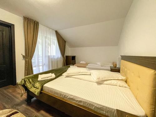 a bedroom with two beds and a window at PENSIUNEA TEOMIR in Pojorâta