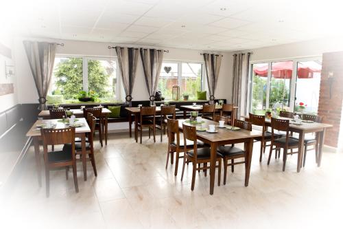 a dining room with wooden tables and chairs at Lohauserhof - Biohof und Hotel in Röhrmoos