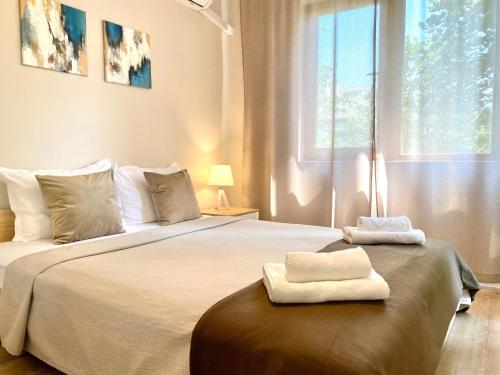a bedroom with a large bed with two towels on it at City Centre Bright & Cozy Apartment for 4 persons in Stara Zagora