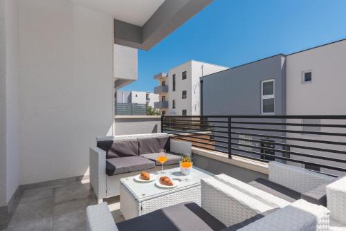 a balcony with a couch and a table with drinks on it at Villa Lovric in Makarska