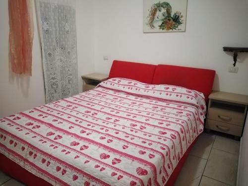 Baia Di GallipoliにあるBaia Verde, Villino indipendenteの赤と白の毛布が敷かれた赤のベッド