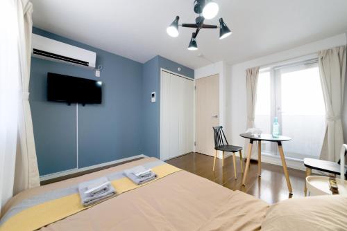 a bedroom with a bed and a flat screen tv at nestay inn tokyo ryogoku in Tokyo