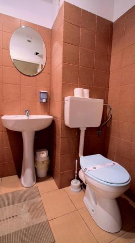 a bathroom with a toilet and a sink at Hotel Mon Caprice in Bucharest