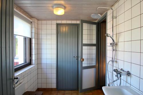 uma casa de banho com uma porta verde e uma banheira em Villa Taikinajoki em Pertunmaa