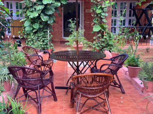 a patio with a table and chairs in a garden at Yelagiri Villa in Yelagiri