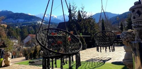 two chairs on a patio with mountains in the background at Casa Daniel in Bran