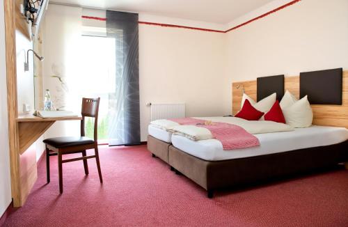 1 dormitorio con 1 cama grande con almohadas rojas en Lohauserhof - Biohof und Hotel, en Röhrmoos