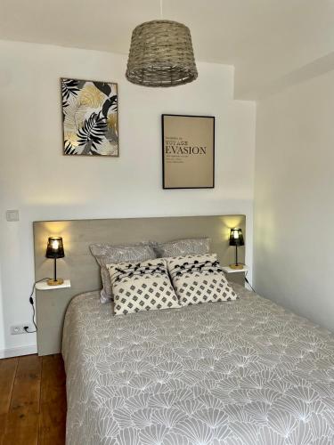 een slaapkamer met een bed en twee foto's aan de muur bij La Romantica**** 4/6 Pers 5kms de Nausicaa in Saint-Étienne-au-Mont