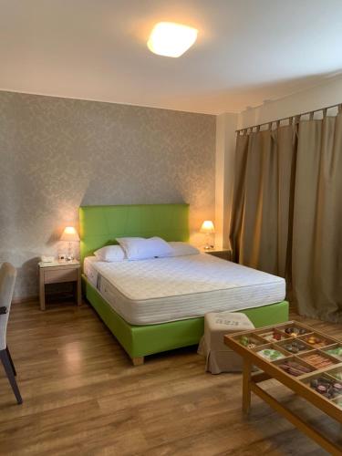 een slaapkamer met een groen bed en een tafel bij Rivitel Marousi Apartments in Athene