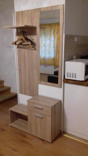 a kitchen with a cabinet and a mirror and a microwave at Tiszafa Apartman in Csopak